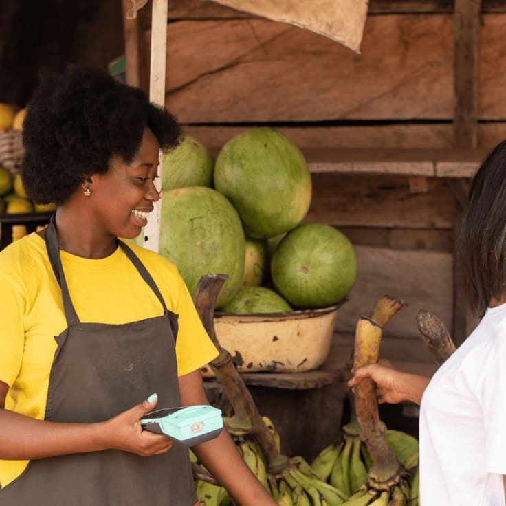 Shop owner welcoming a customer at her market stall